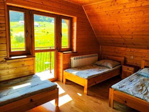 Habitación con 2 camas en una cabaña de madera en Jeleni Skok, en Cisna