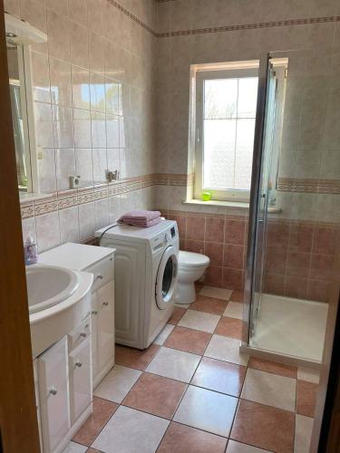 a bathroom with a washing machine and a sink at Apartament Dąbrówno in Dąbrówno