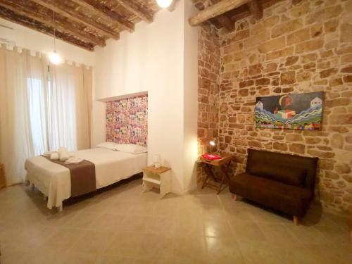 バーリにあるAppartamento Santa Manna, Bari Vecchiaのレンガの壁、ベッド付きのベッドルーム1室