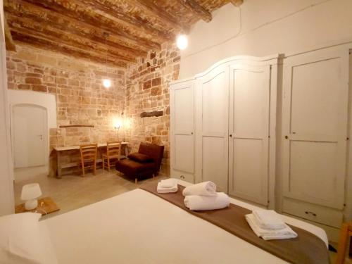 バーリにあるAppartamento Santa Manna, Bari Vecchiaのベッド1台、椅子、テーブルが備わる客室です。