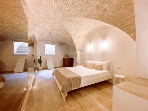 a bedroom with a bed in a room with a stone ceiling at INDE Á LA TERRE, GUEST HOUSE Locazione Turistica in Molfetta