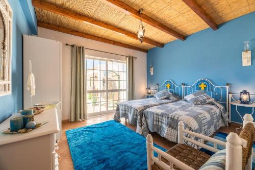 ein Schlafzimmer mit 2 Betten und einer blauen Wand in der Unterkunft Villa Galé Sun - Luxury, 5bed with free wifi, AC, private pool, 5 min from the beach in Guia