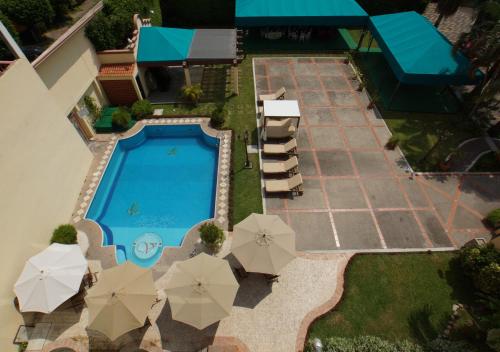 an overhead view of a swimming pool with umbrellas at Hotel Victoria Poza Rica by Brahma in Poza Rica de Hidalgo
