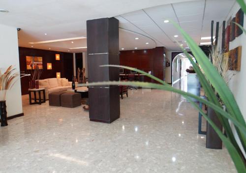 a lobby with a couch and a table in a building at Hotel Victoria Poza Rica by Brahma in Poza Rica de Hidalgo