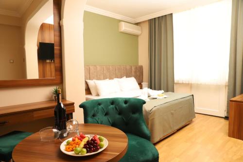 a room with a bed and a table with a bowl of fruit at Buldum Otel in Ankara