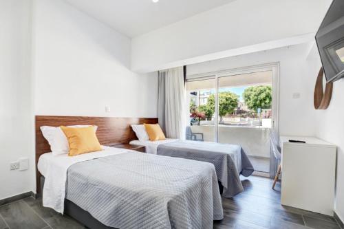 アヤナパにあるMyHome DeLux, Ayia Napa 3 Bedroom with Poolのベッド2台とバルコニー付きのホテルの部屋