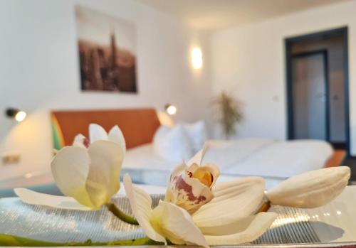 a white flower on a plate on a table at Hotel Marktbrauerei in Bad Lobenstein