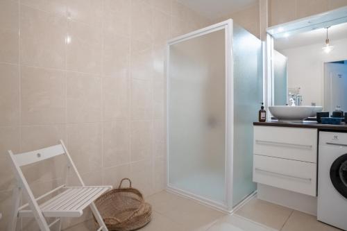 La salle de bains est pourvue d'une douche, d'un lavabo et d'une chaise. dans l'établissement Le Regatta, à Arcachon