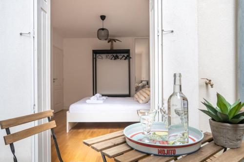 Cette chambre comprend une table et une bouteille de vin. dans l'établissement Le Regatta, à Arcachon