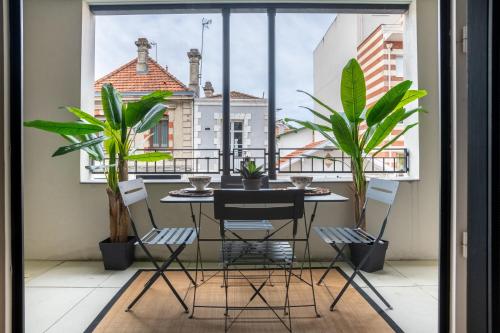 d'un balcon avec une table, des chaises et des plantes. dans l'établissement Le Regatta, à Arcachon