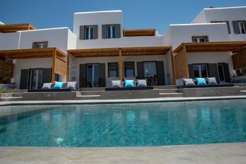 a house with a swimming pool in front of a house at CASA DI PIETRA MYKONOS in Klouvas
