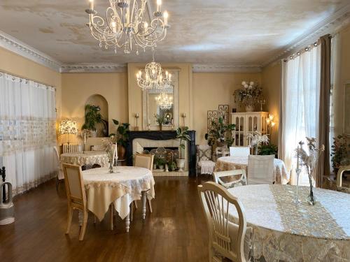 uma sala de jantar com mesas e cadeiras e um lustre em The Corner Properties em Noirmoutier-en-l'lle