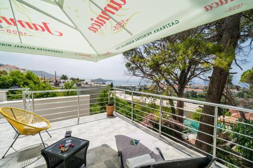 a balcony with a table and chairs and an umbrella at Apartment Eulalija in Dubrovnik