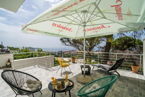 a patio with chairs and an umbrella on a balcony at Apartment Eulalija in Dubrovnik
