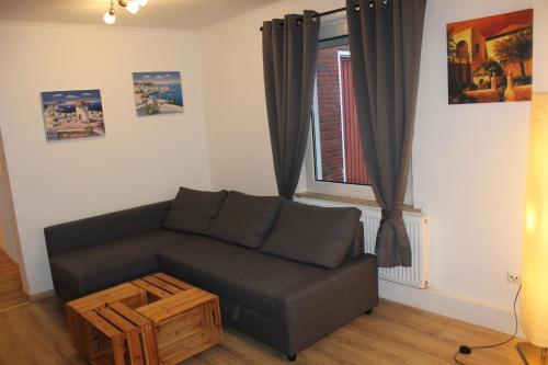 a living room with a couch and a window at AAR Nordsee Appartement in Varel