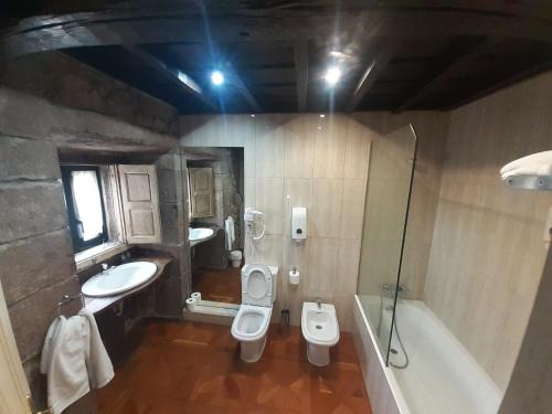 a bathroom with two sinks and a toilet and a tub at La Casona de Barrio in Barrio