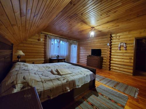 a bedroom with a bed in a log cabin at Gostynniy Dvir in Forest Коттеджи in Migovo