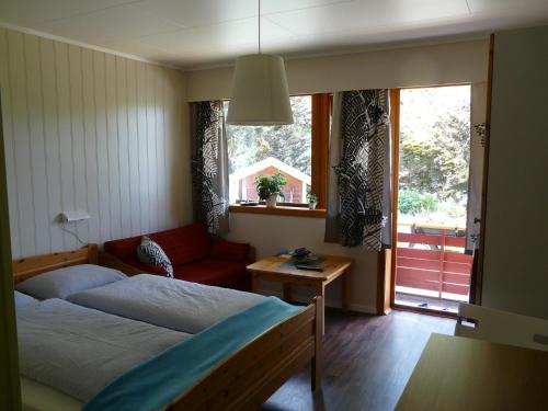 a bedroom with a bed and a couch and a window at Kvamsdal Pensjonat 2 in Eidfjord