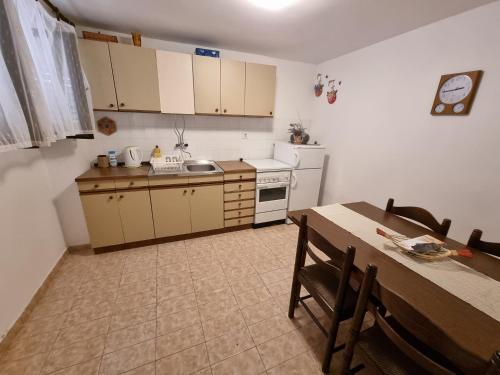 eine Küche mit einem Tisch und eine Küche mit einem Tisch und Stühlen in der Unterkunft Apartment Anna Vis in Vis