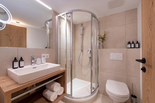 a bathroom with a shower and a sink and a toilet at Bühlhof Appartements in Lech am Arlberg