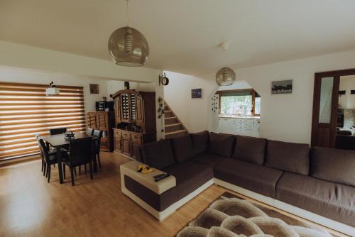 a living room with a couch and a table at Căsuța de sub deal - Ciubăr și piscină in Măgura