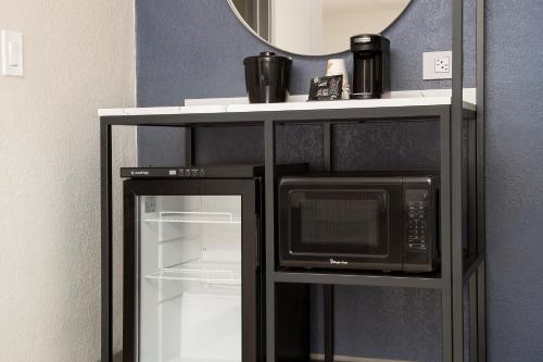 a microwave oven on a stand with a mirror at Rodeway Inn St Augustine Historic District in Saint Augustine