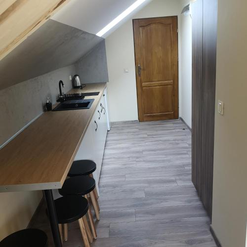 a kitchen with a sink and a counter with stools at Janickowa Ostoja - Noclegi w Zakopanem in Zakopane