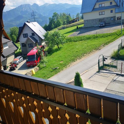 a balcony with a view of a road and a red truck at Janickowa Ostoja - Noclegi w Zakopanem in Zakopane