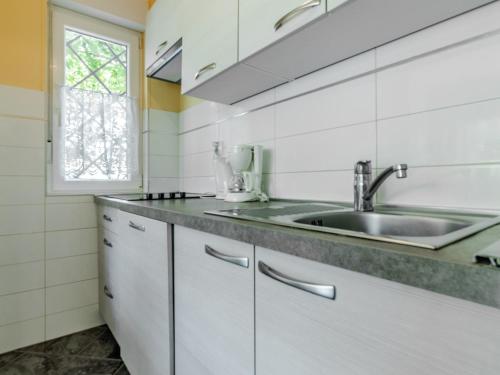 a white kitchen with a sink and a window at Villa Mimoza in Banjole