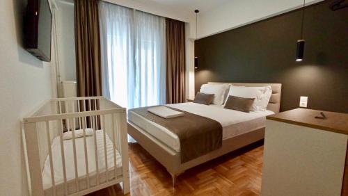 a bedroom with a bed and a crib in it at EPaN Luxury Apartments in Thessaloniki