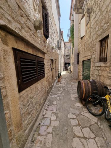 an alley with a barrel on the side of a building at Apartment Anna Vis in Vis