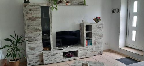 ein hölzernes Entertainment-Center mit einem TV im Wohnzimmer in der Unterkunft  Feriendomizil Roger Wohnung 1 in Leipzig