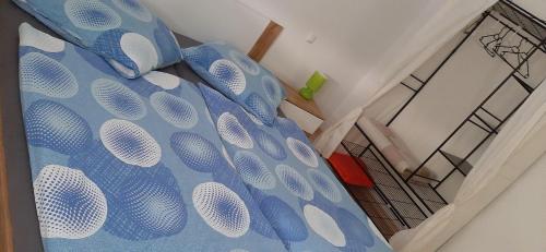 ein Bett mit blauen und weißen Kissen darauf in der Unterkunft  Feriendomizil Roger Wohnung 1 in Leipzig