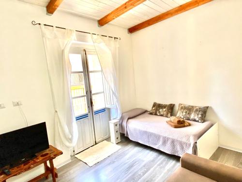 una camera da letto con un letto, una tv e una finestra di Maestrale a Tertenìa