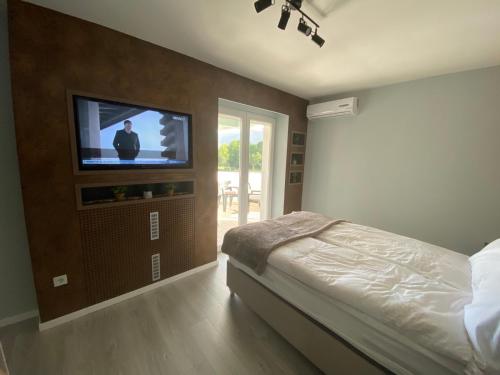 a bedroom with a bed and a flat screen tv at Diamond apartments in Sarajevo