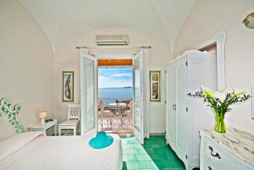 a bedroom with a bed and a view of the ocean at Villa La Tartana in Positano