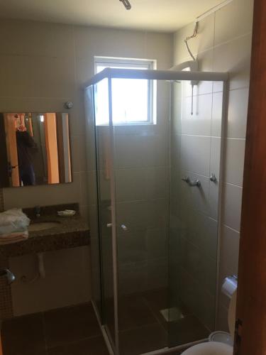 a bathroom with a shower with a glass door at POUSADA TAQUARAS in Cassino