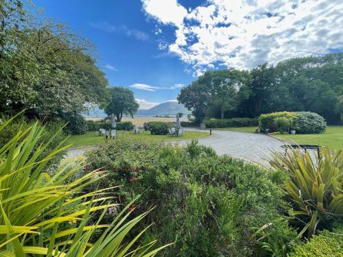 a walkway through a park with trees and bushes at Loch Lein Country House in Killarney