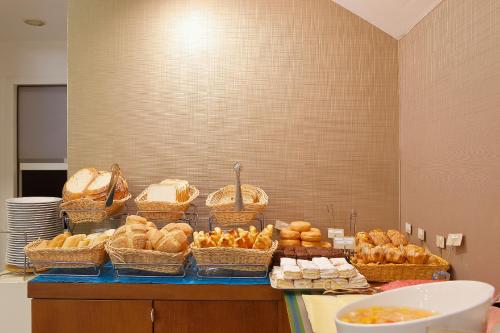 a buffet with baskets of bread and pastries on a counter at Hotel Santa Rosa, Blue Hoteles in Gijón