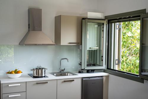 a kitchen with a sink and a window at OLEA Luxury Apartments in Parga