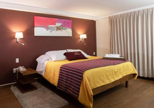 a hotel room with a bed with a yellow blanket at Hotel Victoria Poza Rica by Brahma in Poza Rica de Hidalgo