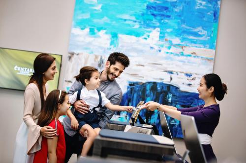 a group of people standing around a man holding a child at Centara West Bay Hotel & Residences Doha in Doha