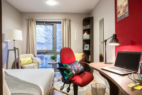 a room with a desk with a laptop and a red chair at Stunning Apartments at Dashwood Studios in London in London