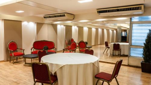 einen Tagungsraum mit einem weißen Tisch und Stühlen in der Unterkunft Hotel Metropol in San Miguel de Tucumán
