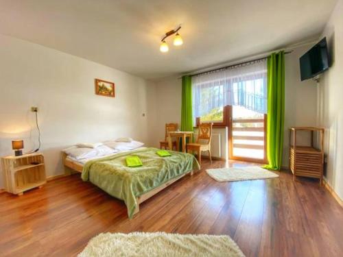 Schlafzimmer mit einem Bett, einem Tisch und einem Fenster in der Unterkunft Wypoczynek Pod Skarpą in Chochołów