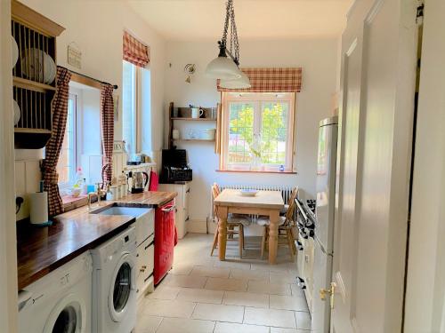 a kitchen with a washing machine and a table at Gwydyr House in Ryde