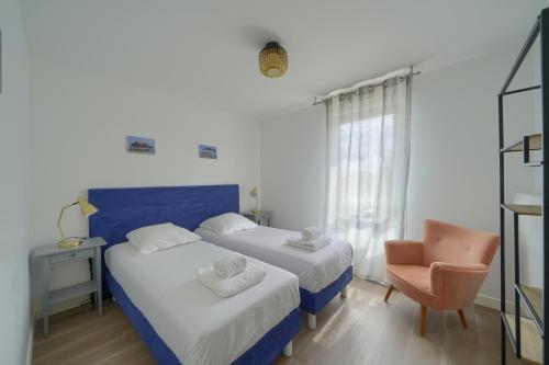 a hotel room with two beds and a chair at La Carasse in Lège-Cap-Ferret