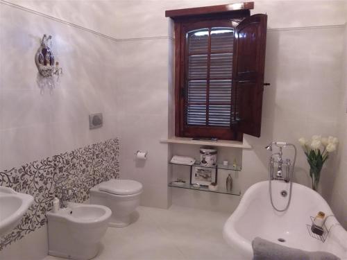 a white bathroom with a toilet and a sink at Casa Verde in Monticchio