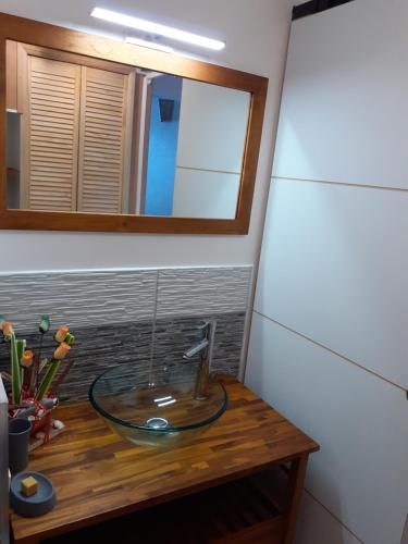 a glass bowl on a wooden table in a bathroom at Studio Caliente vue panoramique Rocher du Diamant in Le Diamant