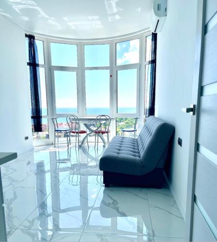 a living room with a couch and a table and chairs at Апартаменты у моря с панорамным видом Золотой Берег in Odesa